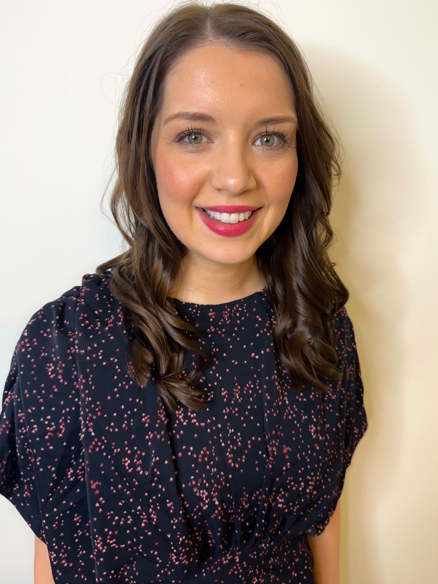 A 3-dimensional image of a book showing a woman in historical clothing and a tartan wrap on her arms standing in the Scottish Highlands. A walking trail is seen behind her disappearing into the mountains. The title of the book is Smoke on the Wind by USA Today bestselling author Kelli Estes.